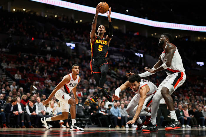 Mar 13, 2024; Portland, Oregon, USA; Atlanta Hawks guard Dejounte Murray (5) scores a basket on a layup during the first half against Portland Trail Blazers forward Justin Minaya (24), forward Kris Murray (8), and center Deandre Ayton (2) at Moda Center. Mandatory Credit: Troy Wayrynen-USA TODAY Sports